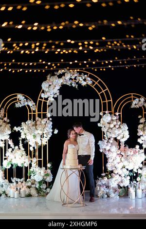 newlyweds happily cut, laugh and taste the wedding cake Stock Photo