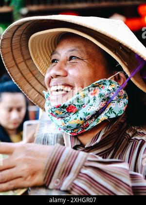 Smiling Vietnamese woman selling her products at the market. Stock Photo