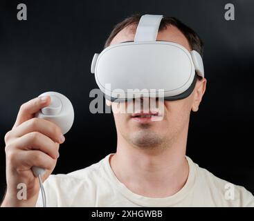 Man in white VR headset front view isolated on black studio background Stock Photo