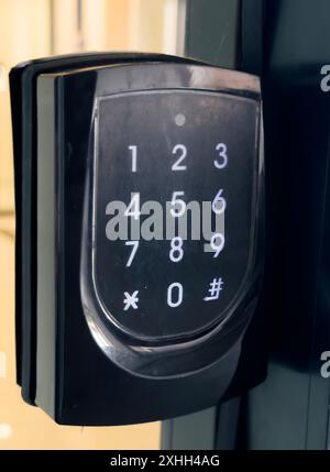 A close-up of a black keypad door lock with a numerical keypad. Stock Photo