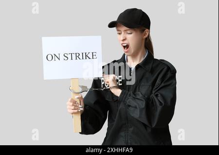 Young police officer holding handcuffs Stock Photo - Alamy