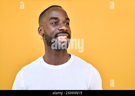 Smiling Black young man looking away at copy space advertising promotion. Stock Photo