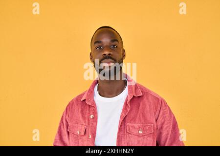 Portrait of confident young African man hipster standing isolate on yellow wall. Stock Photo