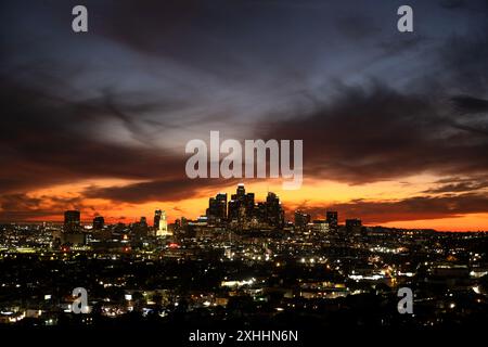 Dramatic dusk sky over downtown Los Angeles skyline with lights of the city shining in the evening Stock Photo
