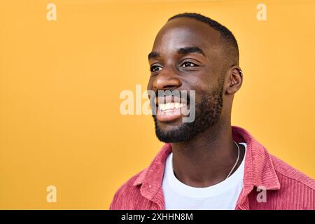 Smiling Black young man looking away at copy space advertising promotion. Stock Photo