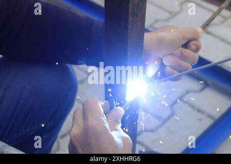 Welding man working on iron welding in construction site. Close up. Stock Photo
