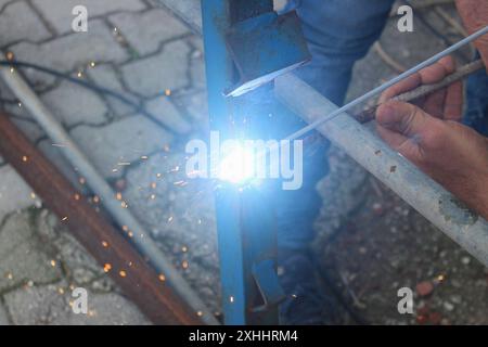 Welding man working on iron welding in construction site. Close up. Stock Photo