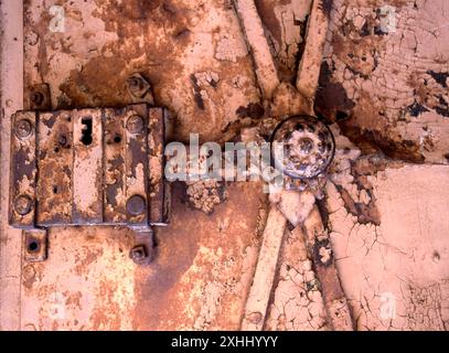 Old rusty iron lock on the front metal door of a building Stock Photo