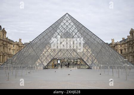 Paris, France. 14th July, 2024. Entrance of the Louvre Pyramid during the Olympic Torch Relay in front of the Louvre Pyramid, designed by Chinese-US architect Ieoh Ming Pei, in Paris on July 14, 2024, ahead of the upcoming Paris 2024 Olympic Games. Photo by Raphael Lafargue/ABACAPRESS.COM Credit: Abaca Press/Alamy Live News Stock Photo