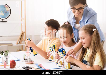 Elementary School Students Building Robots With Teacher Stock Photo