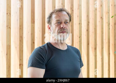 Portrait of a stylish and bearded man aged 50-55 on a textured wooden background. Stock Photo