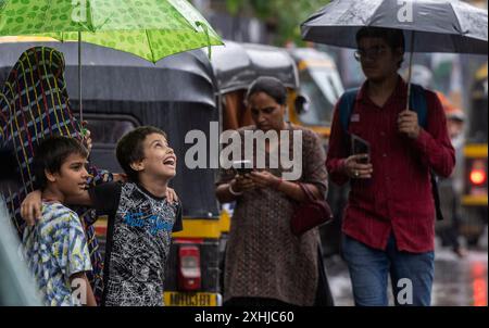 Mumbai, India. 14th July, 2024. MUMBAI, INDIA - JULY 14: People going through the rain at Powai, on July 14, 2024 in Mumbai, India. (Photo by Satish Bate/Hindustan Times/Sipa USA ) Credit: Sipa USA/Alamy Live News Stock Photo