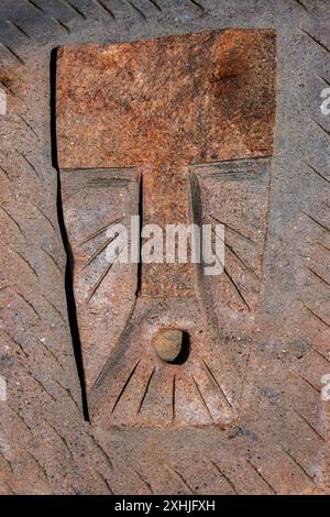 Stone carvings of masked faces on a rock at Inuit sculpture park by the Four Corners in Iqaluit, Nunavut, Canada Stock Photo