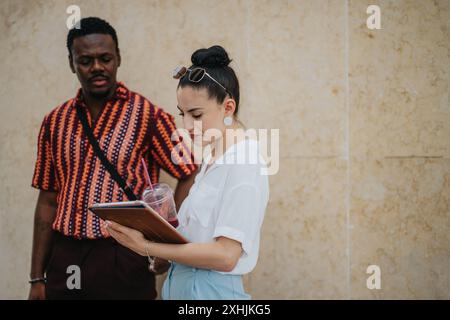 Business people collaborating outdoors with tablet in urban city setting Stock Photo
