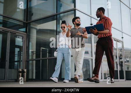Young business professionals collaborating and walking in an urban city environment Stock Photo