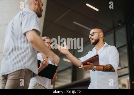 Businesspeople having a productive outdoor meeting in urban downtown area Stock Photo