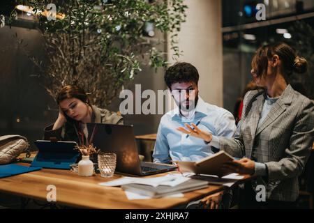 Startup team collaborating on a new project at a casual coffee bar late at night Stock Photo