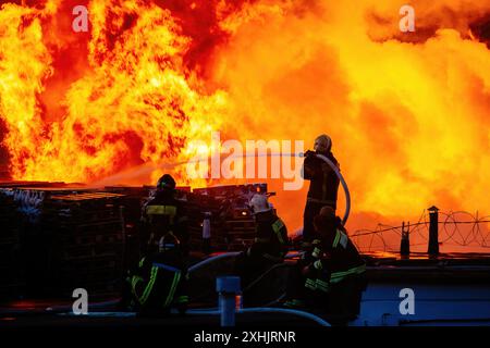 Firefighters extinguish burning industrial building in the city. Stock Photo