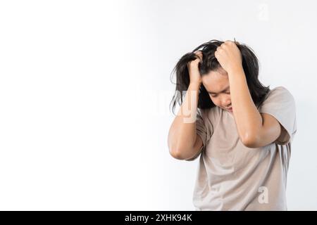 Young asian woman hand touching head she's feeling depressed stress headache be tired from working standing on isolated white background she has sympt Stock Photo