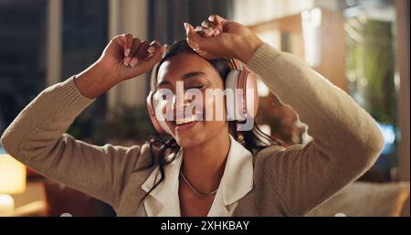 Woman, dancing and headphones for streaming music with rhythm, hip hop playlist and happy for radio song in home. Female person, sound tech and smile Stock Photo