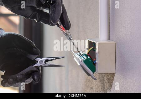Electrician working safely on sockets of a residential electrical system Stock Photo