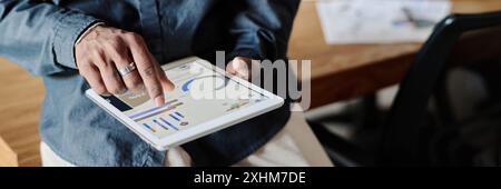 Website header shot of unrecognizable male hands holding tablet with launched app showing recent analytical analysis Stock Photo
