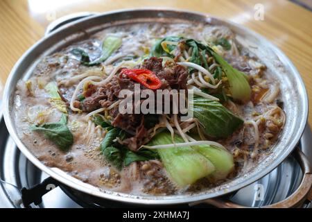 Korean dish that is eaten by boiling sweetly seasoned bulgogi with various vegetables and glass noodles Stock Photo