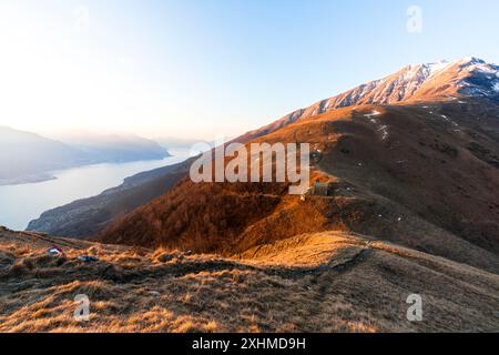Misty sunrise over a small church on mountains above Lake Como, Italy Stock Photo