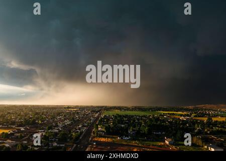 Dramatic storm clouds sweep across the sky at sunset. Stock Photo