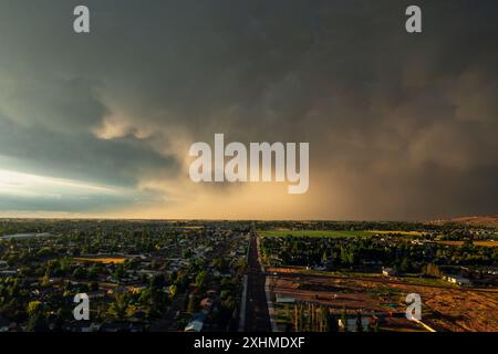 Dramatic storm clouds sweep across the sky at sunset. Stock Photo