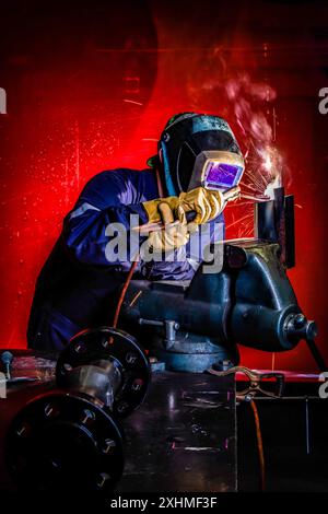 Welding in heavy machine shop Stock Photo