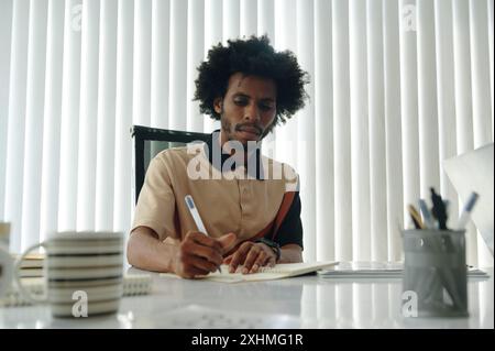 Businessman Making Notes At Meeting Stock Photo