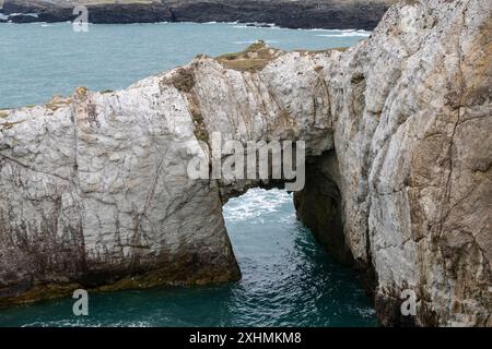 Bwa Gwyn rock arch near Rhoscolyn, Anglesey, North Wales. Stock Photo
