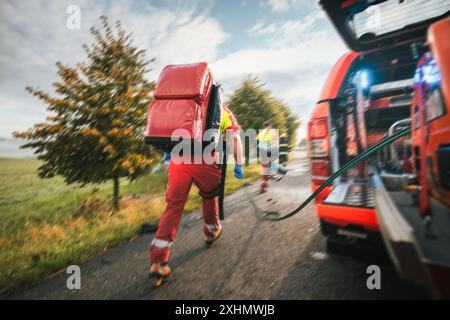 Paramedic and doctor of emergency medical medical service in blurred motion. Team of rescuers running to traffic accident. Themes rescue, urgency and Stock Photo