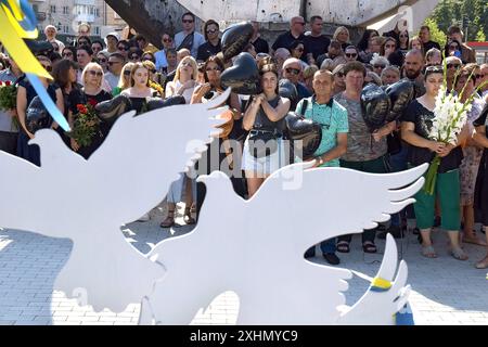 VINNYTSIA, UKRAINE - JULY 14, 2024 - People pay tribute to the victims of the Russian missile strike on downtown Vinnytsia on July 14, 2022, at the ‘To the Victims of Missile Attacks on Vinnytsia’ memorial in Peremohy Square, Vinnytsia, west-central Ukraine. Twenty-nine people, including three children, were killed by the attack. Stock Photo