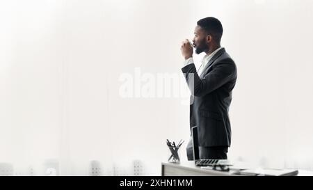 Businessman Drinking Coffee by Window Stock Photo