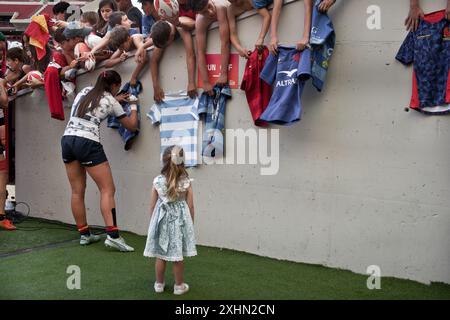 A player of the Spanish female Rugby Sevens national team signing rugby shirts to kids, after a match during the Madrid Sevens. Stock Photo