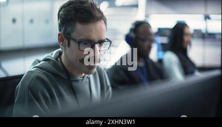 Close Up of a Software Developer Working on a Computer, Typing Programming Code on a Stylish Keyboard with Neon Backlight. Professional Employee Doing Work in a Cyber Security Technology Company Stock Photo