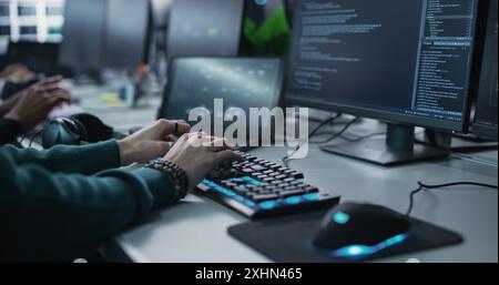 Close Up of a Software Developer Working on a Desktop Computer, Programming Code Running on Display. Specialist Typing on Keyboard, Coding and Implementing a Technical Feature, Working in an Agency Stock Photo