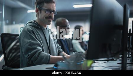 Young Passionate Specialist Working on Computer, Programming a Software for an Innovative Technological Internet Product Launch. Diverse Multicultural Team Working in a Startup Agency Stock Photo