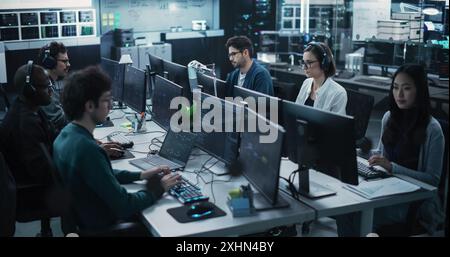Team of Six Diverse Multiethnic Software Developers Working on Computers, Programming Advanced Code, Managing Artificial Intelligence Projects Online for Innovative Internet Based Blockchain Stock Photo