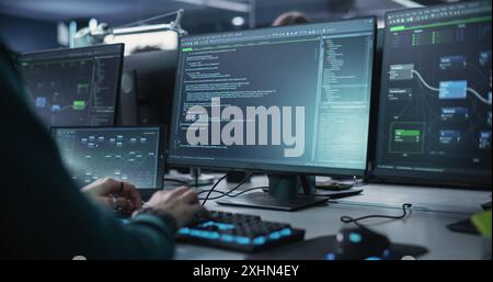 Close Up of a Software Developer Working on a Desktop Computer with Green Screen Mock Up Display. Specialist Typing on Keyboard, Coding and Implementing a New Technical Feature, Working in an Agency Stock Photo