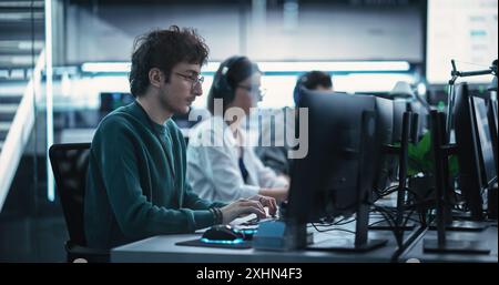 Young Creative Manager Using Computer, Writing a Project Plan for an Innovative Technological Internet Product Launch. Diverse Multicultural Team Working in a Startup Company Stock Photo