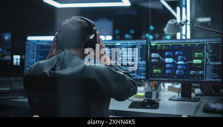 Young Hacker Working Alone, Hacking Corporate Data Servers From His Underground Hideout. Hacktivist Organizes a Massive Data Breach Cyber Attack, Hiding His Identity Behind Multiple Proxy Servers Stock Photo