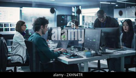 Team of Talented Young Professionals Working in a Technological Research and Development Facility. Diverse Specialists Using Computers, Writing Code, Planning Innovative Information Technology Project Stock Photo