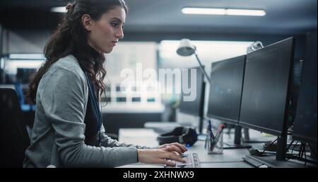 Young Female Artificial Intelligence Engineer Working on Computer in a Technological Office. Young Specialist Writing Software Code for an Innovative Big Data Blockchain Project Stock Photo