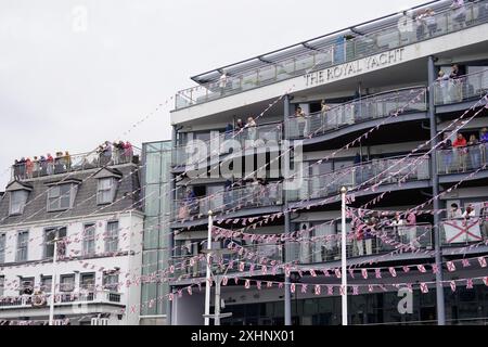 People look out from the Royal Yacht Hotel as King Charles III and Queen Camilla attend the Jersey Expo Event at Weighbridge Place in St Helier, Jersey, during their two day visit to the Channel Islands. Picture date: Monday July 15, 2024. Stock Photo