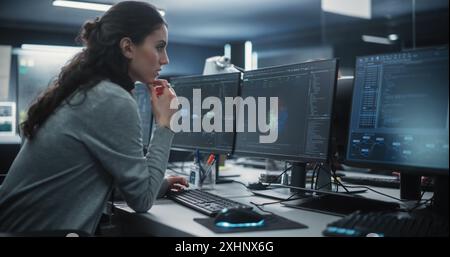 Portrait of a Thoughtful Young Engineer Working on Computer in a Technological Office Environment. Beautiful Multiethnic Woman Writing Software Code for a Blockchain Project Stock Photo
