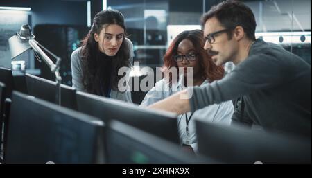 Group of Empowered Multicultural Specialists Working in a Research Center, Using Computer to Collaborate on Advanced Software, Develop Artificial Intelligence Interface and Cloud-Based Blockchain Stock Photo