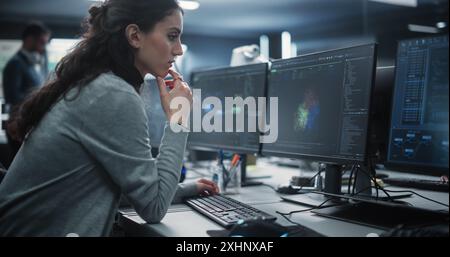 Portrait of a Thoughtful Young Engineer Working on Computer in a Technological Office Environment. Beautiful Multiethnic Woman Writing Software Code for a Blockchain Project Stock Photo